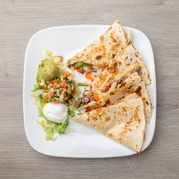 Steak quesadillas with bell peppers and onions, served with guacamole, pico de gallo, and sour cream.