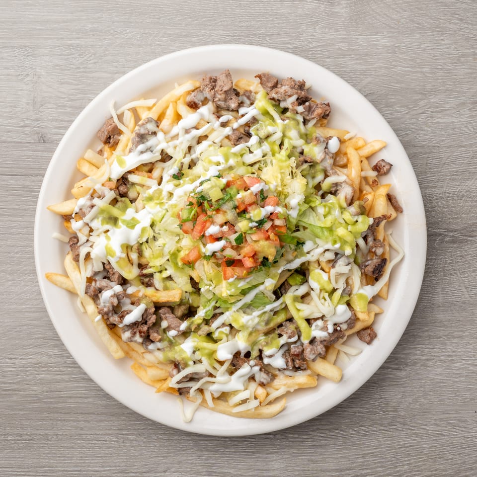 Carne asada fries topped with shredded cheese, sour cream, guacamole, and pico de gallo.